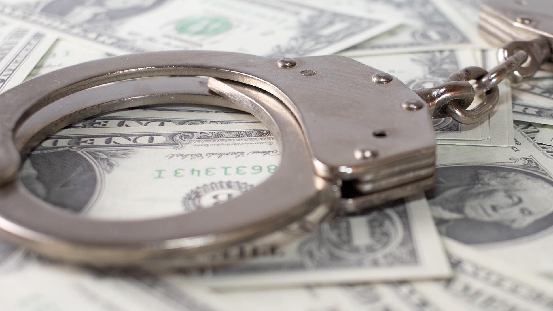 handcuffs on dollar bills