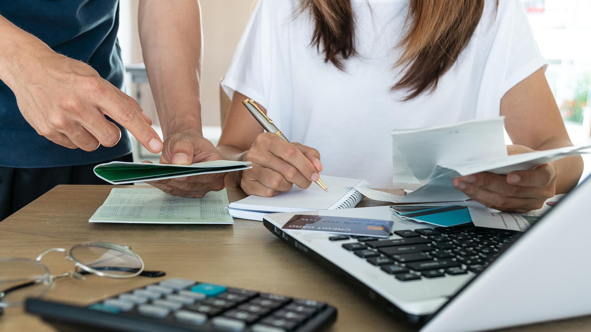 Two students engaged in discussion at a table, surrounded by notes and a calculator